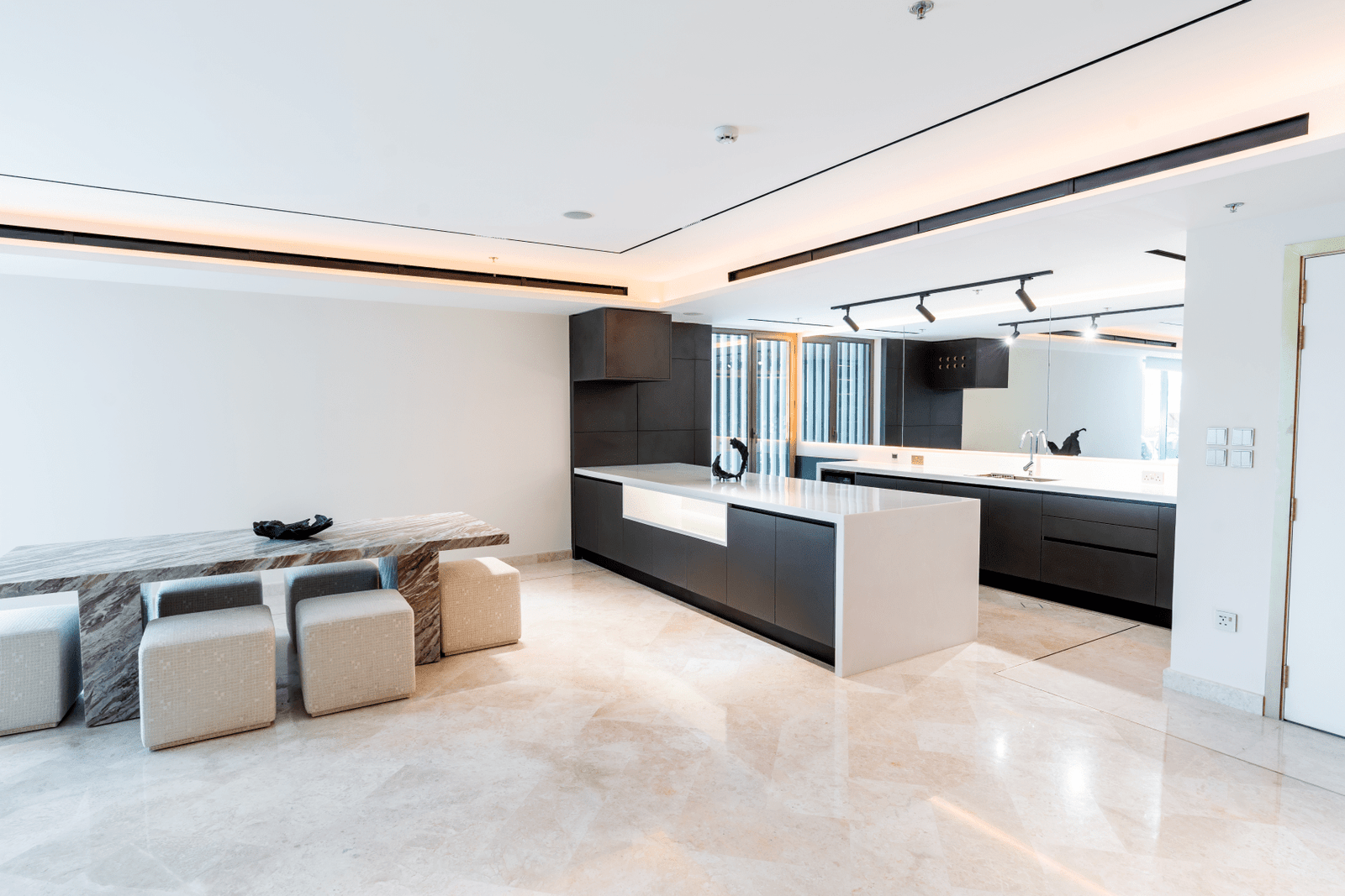 Spacious kitchen and dining area with a marble table and contemporary stools.